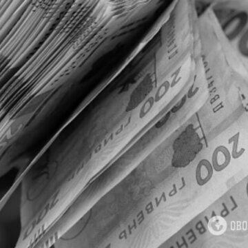 Покупець розраховується готівкою на касі магазину